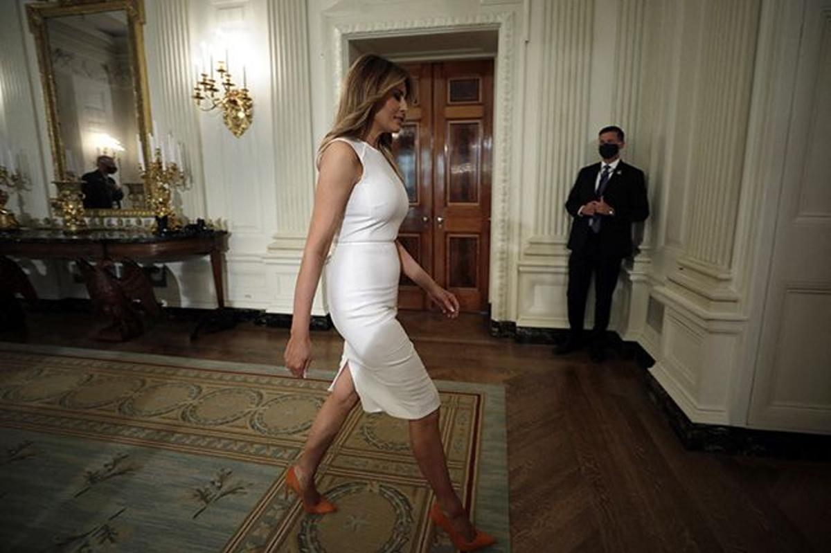 Melania Trump con vestido blanco y zapatos naranjas