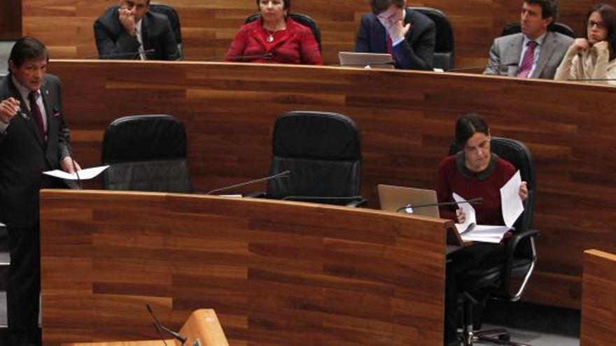 Javier Fernández, de pie, junto a su escaño, durante una de sus intervenciones de ayer, con la consejera de Hacienda, Dolores Carcedo, al otro lado de la bancada.
