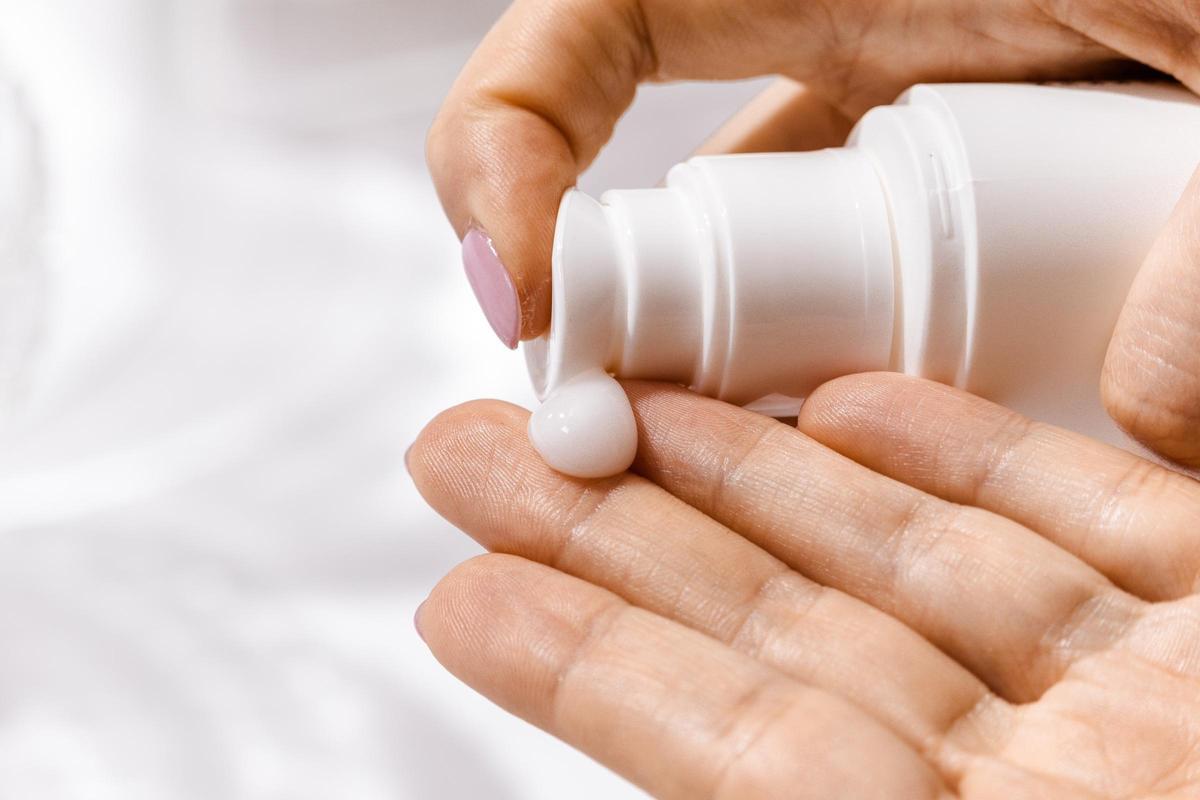 Una persona se protege del sol con crema
