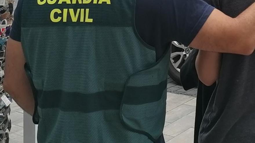 Un agente de la Guardia Civil detiene a un hombre.