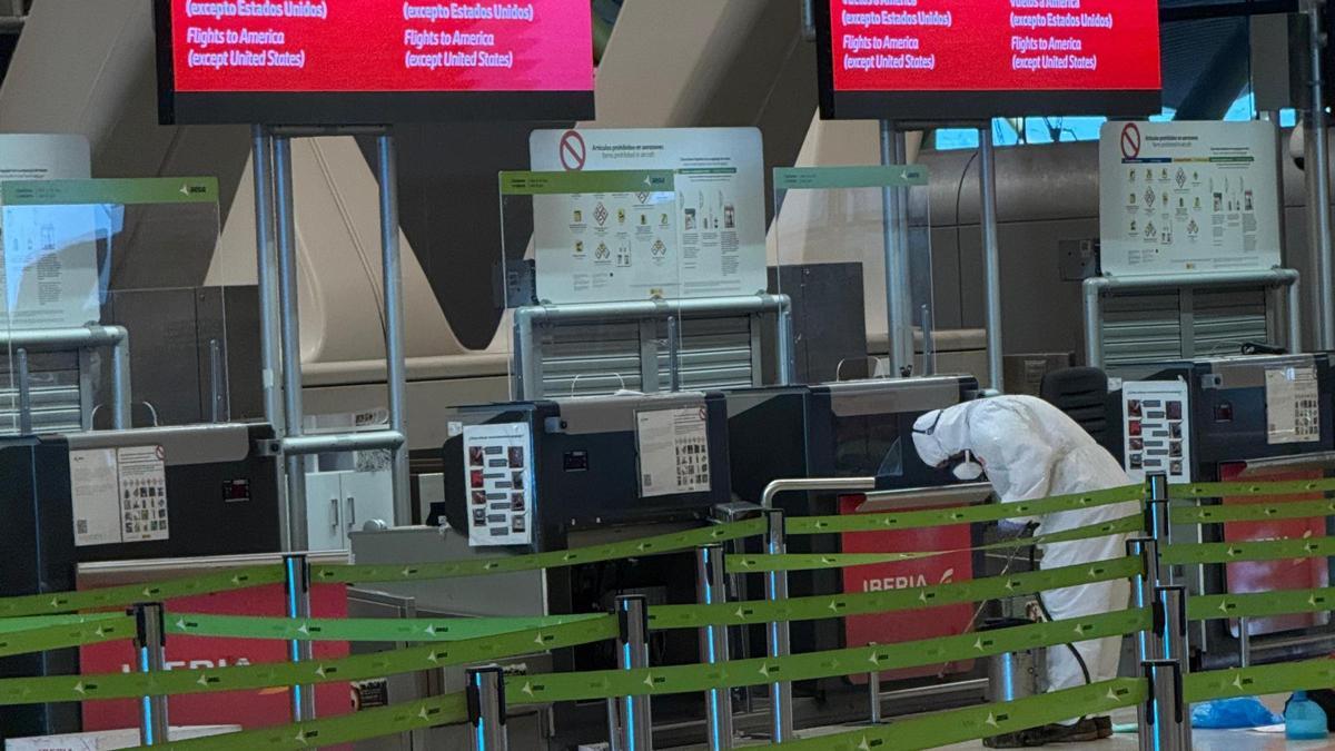 Un operario aplica un tratamiento contra los insectos a un mostrador del aeropuerto
