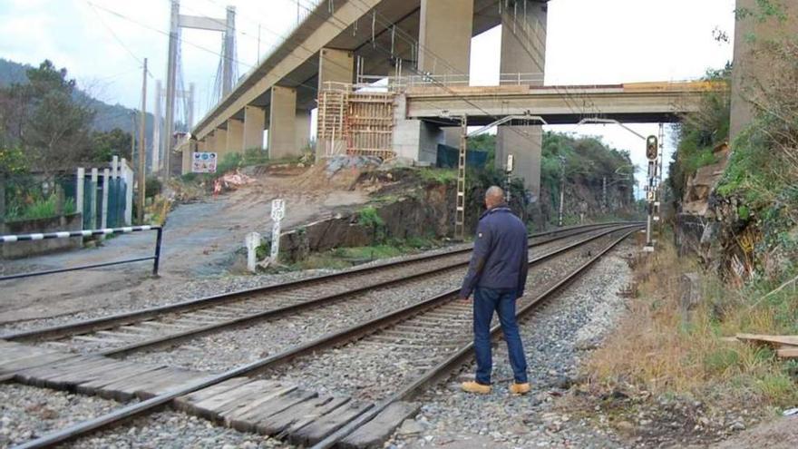 En primer plano el paso a nivel y, al fondo, el nuevo puente que evitará que se atraviesen las vías. // FdV