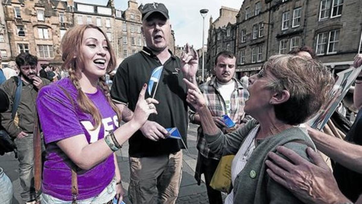Una partidaria del 'sí' a la independencia y una del 'no' expresan en público sus discrepancias, ayer en Edimburgo.