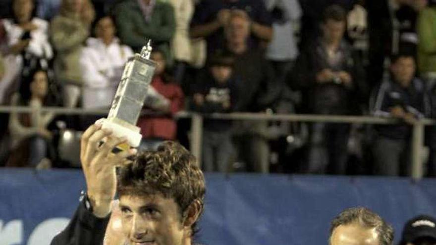 Juan Carlos Ferrero muestra el trofeo de vencedor del Tenis Playa de Luanco de 2008, con Manolo Galé detrás.