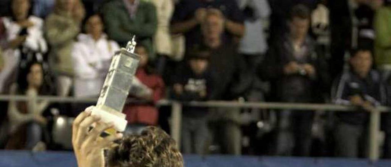 Juan Carlos Ferrero muestra el trofeo de vencedor del Tenis Playa de Luanco de 2008, con Manolo Galé detrás.