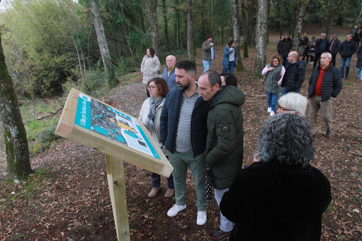 Vecinos de Puga y otras zonas de Toén contemplan el panel divulgativo sobre la historia de los puertos del Miño en la zona.