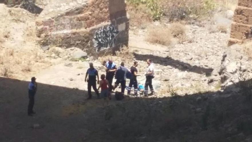 Los vecinos auxilian al hombre que se precipitó desde el puente en Telde