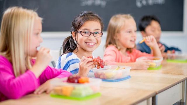 Niños comiendo de 'tuppers'.
