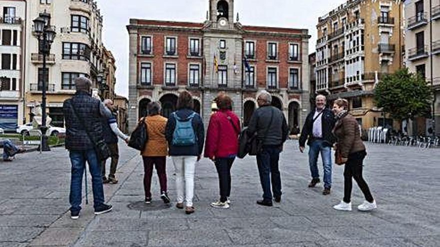 Un grupo de turistas pasea por la Plaza Mayor.