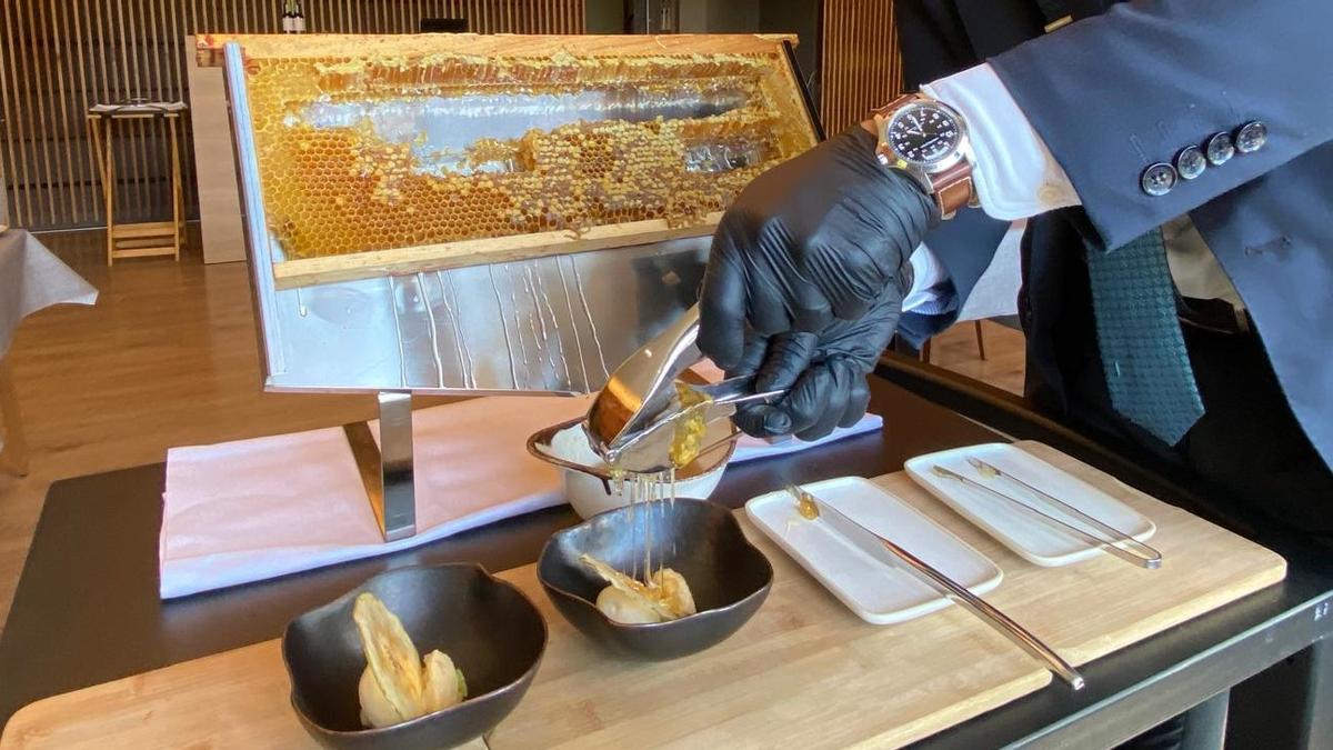 Honey 'squeezed' directly from the honeycomb onto a dessert that is finished in front of the customer at restaurant 1497.