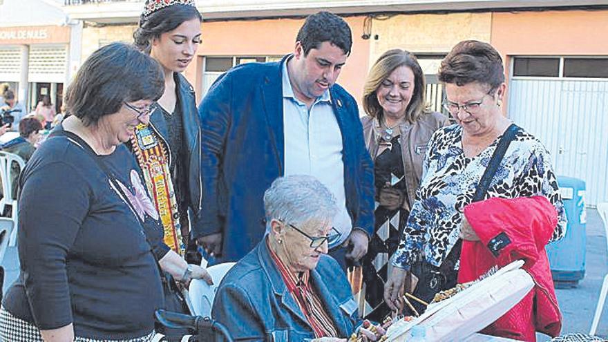 La reina de las fiestas, el alcalde y la edila ven hacer bolillos.