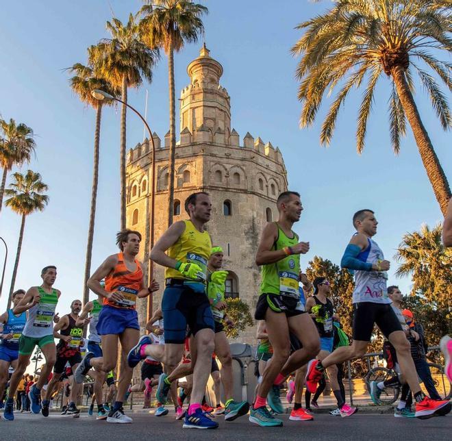 Participantes corren ante la Torre del Oro durante la 36ª edición del Zurich Maratón de Sevilla, en el que se ha proclamado ganador el atleta etíope Mekuant Ayenewcon.