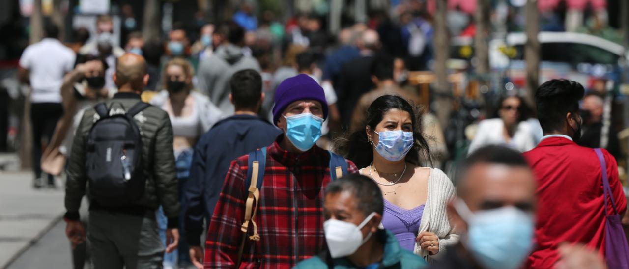 Varias personas con mascarilla caminan en la Gran Vía de Madrid