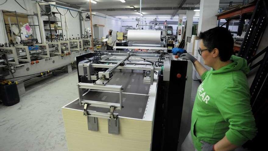 Una de las máquinas que prepara y plastifica el papel para estuches de calidad. // Iñaki Abella
