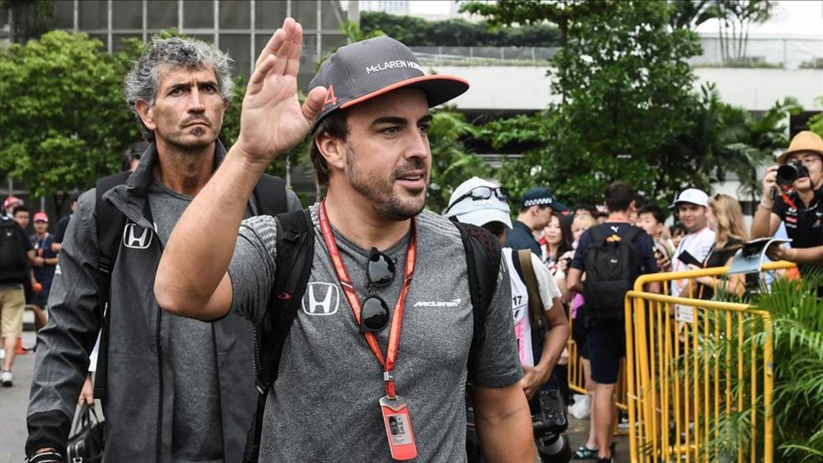 Alonso saluda a los aficionados a la llegada al circuito de Marina Bay