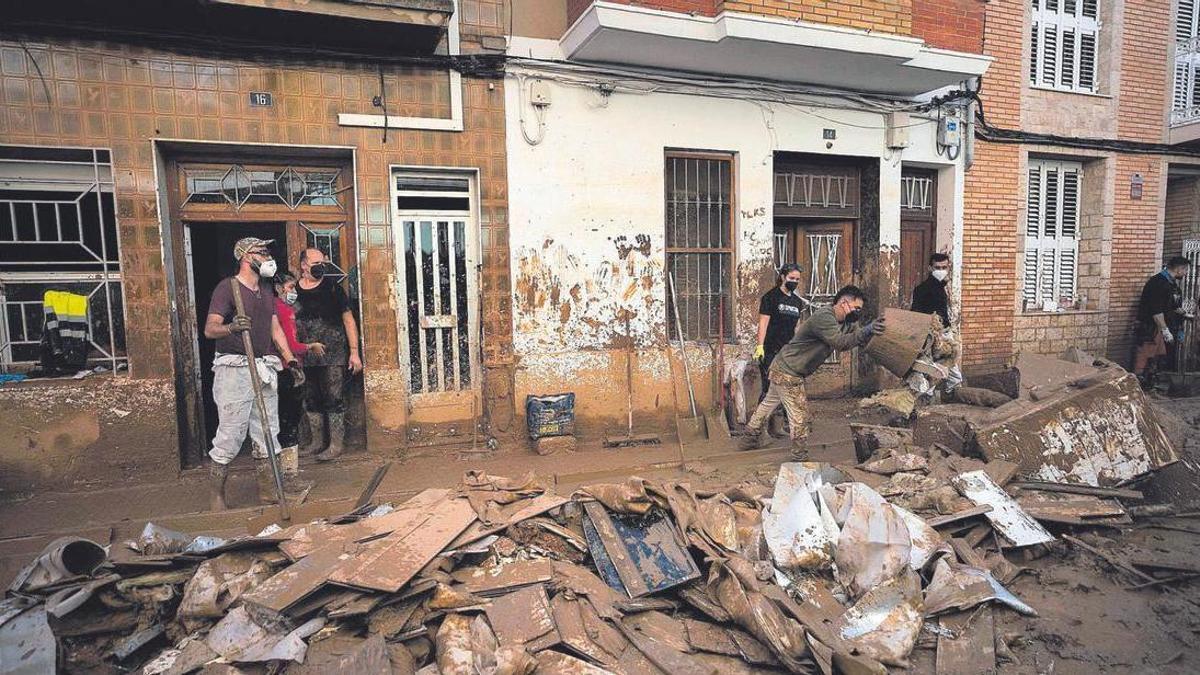 Vecinos de Paiporta sacan enseres y barro de sus viviendas afectadas por la riada del 29 de octubre en una imagen de archivo. VLC. HOR. Paiporta el día 13 tras la catástrofe de la DANA del 29 de octubre de 2024
