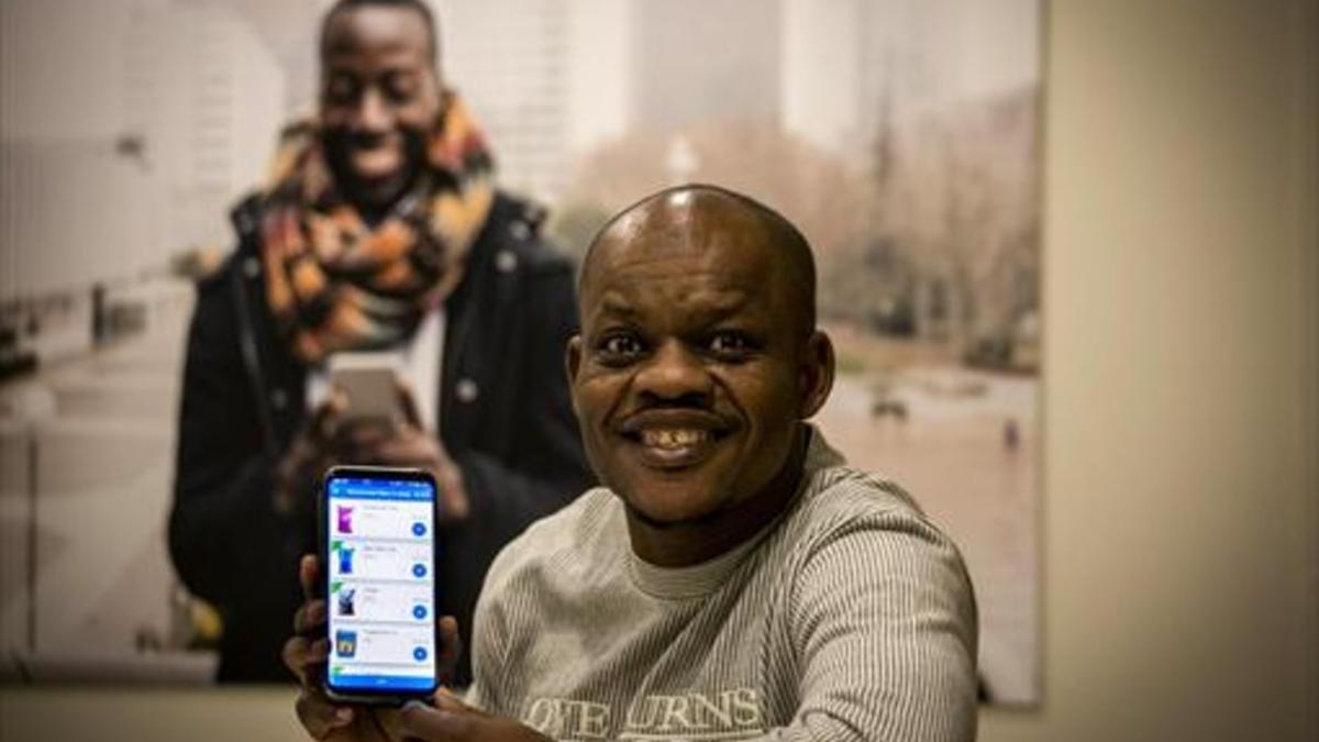 USUARIO. Musa Bala, nigeriano, muestra un móvil con la aplicación.