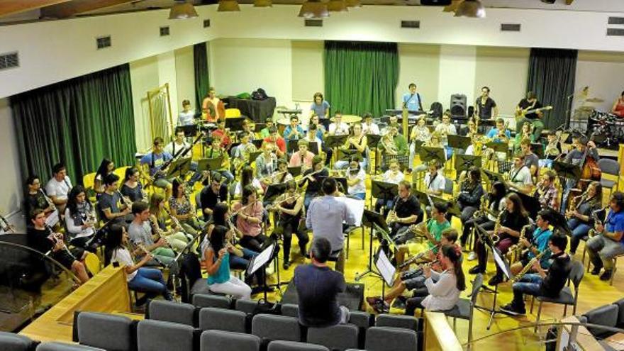 Obeses, Arnau Burdó (teclats i veus), Arnau Tordera (guitarra elèctrica i veu), Jaume Coll (baix) i Maiol Montané (bateria), al darrere, amb la Banda Simfònica del Conservatori de Manresa