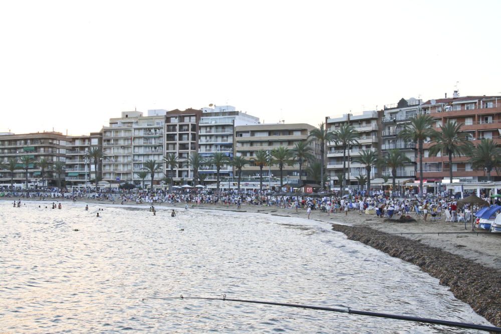 Noche de hogueras, baños, en las playas de la Vega Baja. En las imágenes grupos de amigos y familias en la playa del Cura de Torrevieja