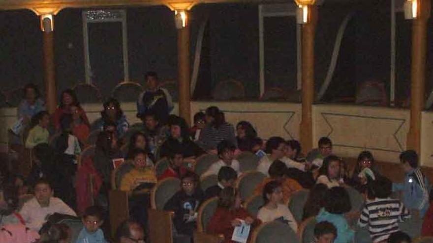 Niños esperan el inicio de una representación en el teatro. Foto