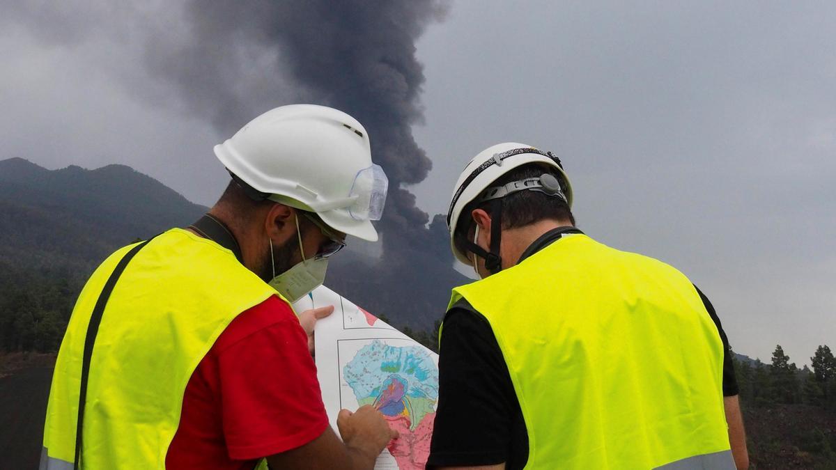 Dos científicos observan el volcán de La Palma.