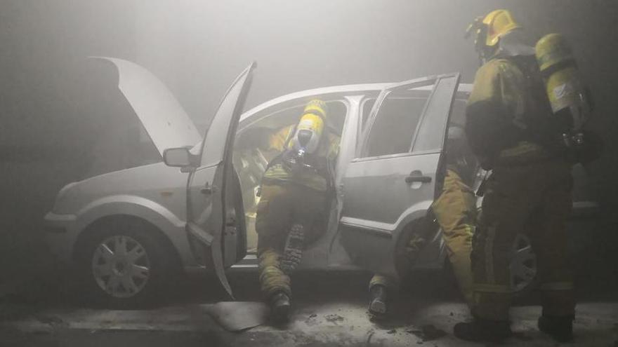 Los bomberos durante las tareas de extinción del coche incendiado el pasado 22 de noviembre