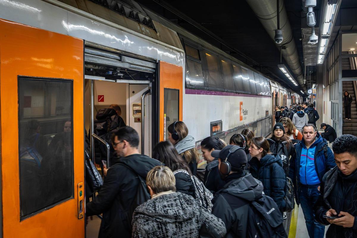 Pasajeros subiendo a un tren de dos pisos en la estación de Sants, en Barcelona.