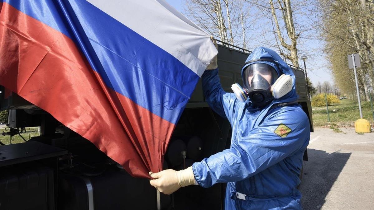 Una mujer muestra una bandera rusa durante una intervención en una residencia sanitaria en la que participaron soldados del Ejército ruso e italiano, el pasado 7 de abril en Treviglio.