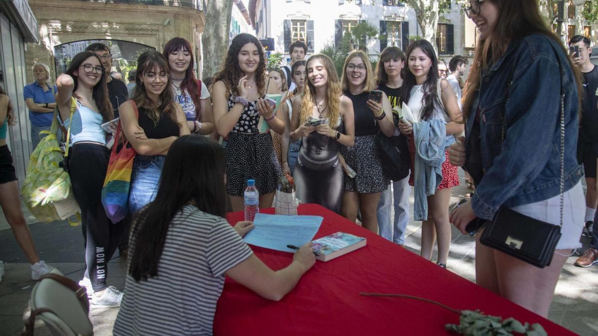 Alice Kellen lee una carta de una de sus fans ante la atenta mirada de otras seguidoras. | GUILLEM BOSCH