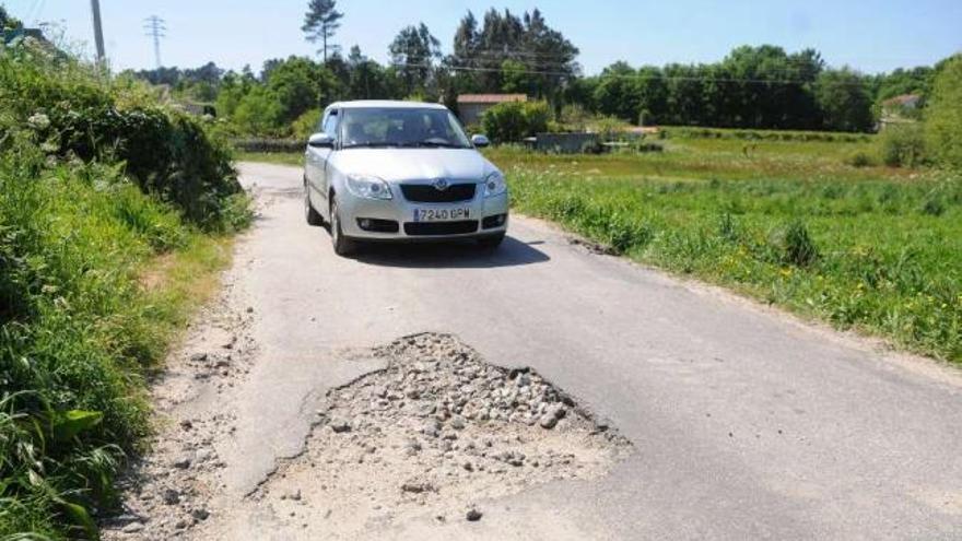 El vial en el lugar de Cons presenta abundantes baches. // Gustavo Santos