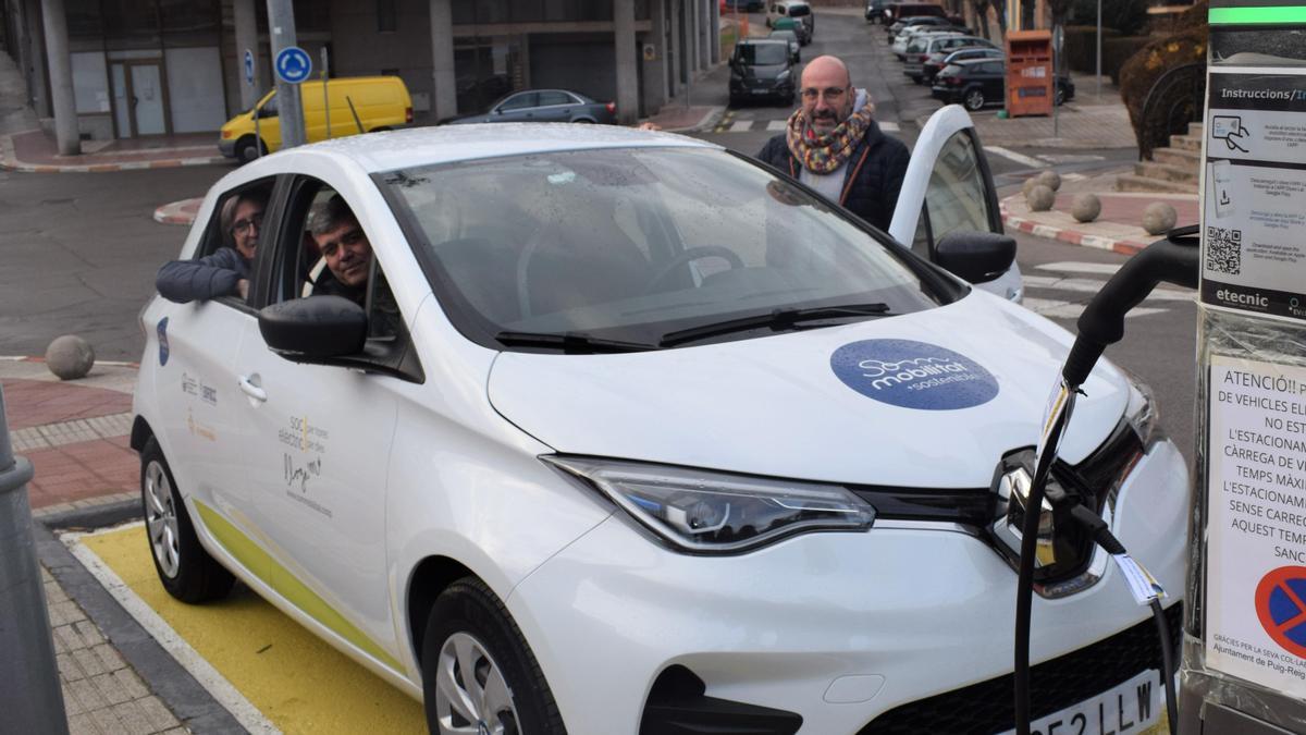 Cotxe elèctric compartit aparcat a Puig-reig amb l'alcalde, Josep Maria Altarriba, i el president de l'Associació  pel Desenvolupament Rural de la Catalunya Central, Jesús Calderer, a dins. A fora, Arnau Vilardell, coordinador de Som Mobilitat