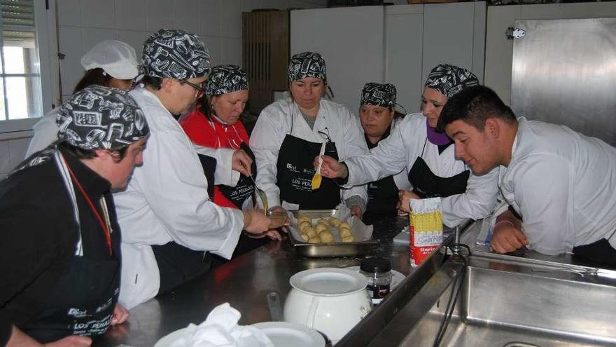 Los alumnos en la cocina elaborando un plato.