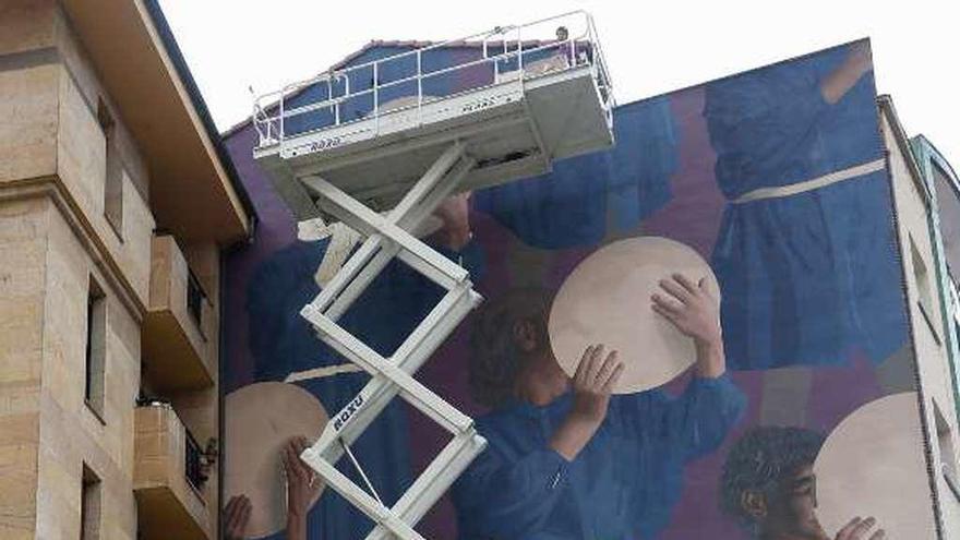 Un viandante se sorprende ante el mural que &quot;Colectivo Licuado&quot; pinta estos días en una medianera del Milán.