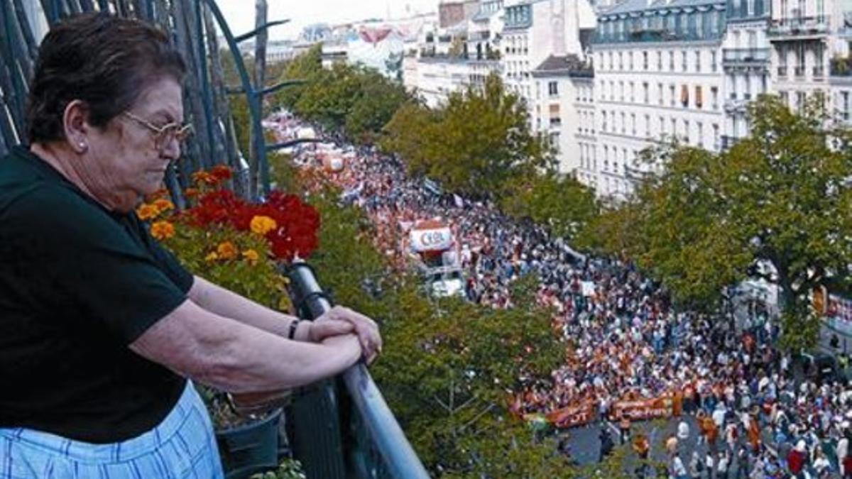 Una mujer observa desde su casa la manifestación de París, ayer.