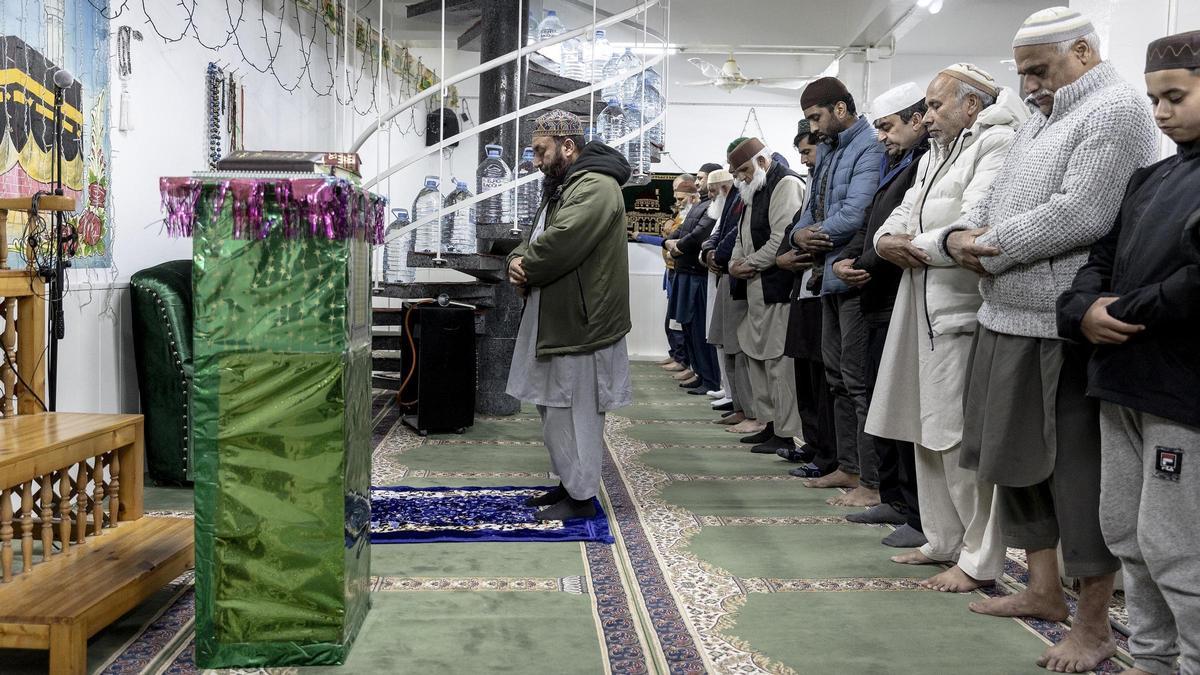 El imán Hafiz Quasar, de verde, dirige la oración en la mezquita 'Ghulamane Mustaffa Catalunya' de Sant Martí