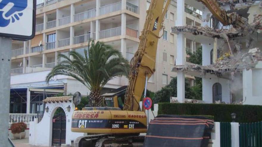 La máquina trabaja en la demolición del Portomar frente a la playa de la Concha.