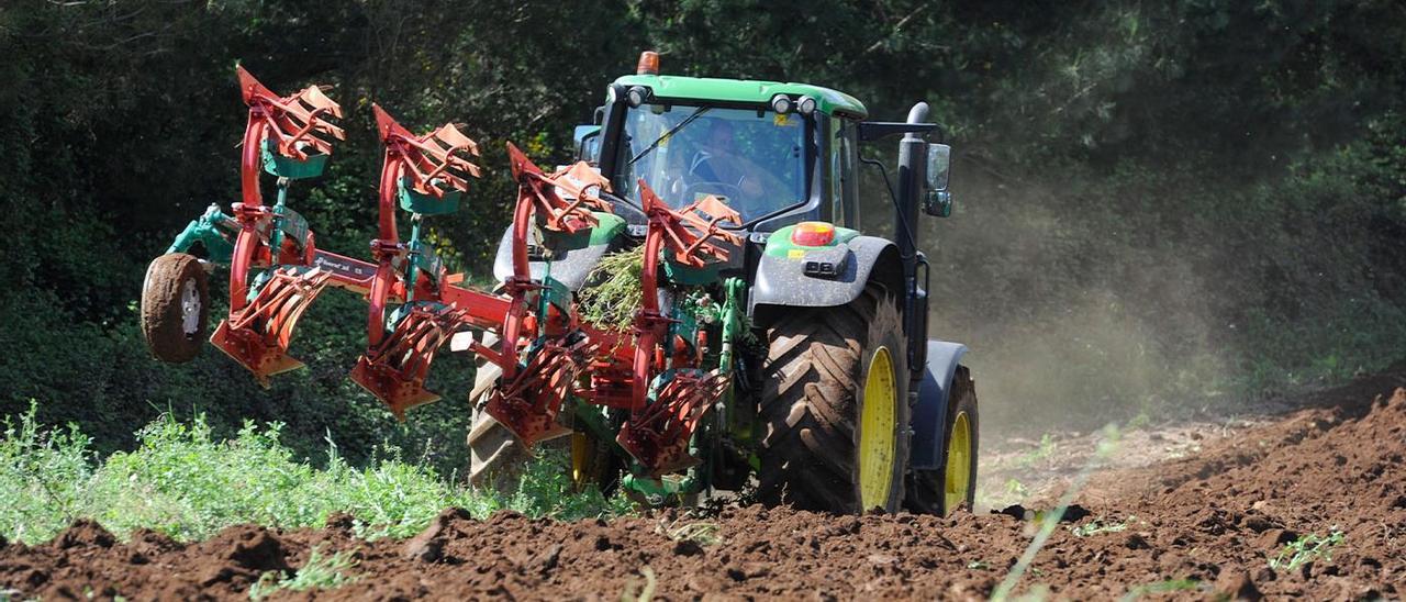 Un tractor arando la tierra en Vila de Cruces.