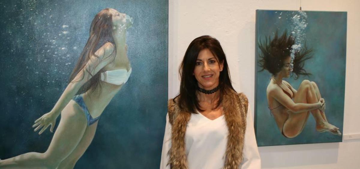 La artista Perla Fuertes, junto con dos obras de la exposición 'Caja de agua II'.