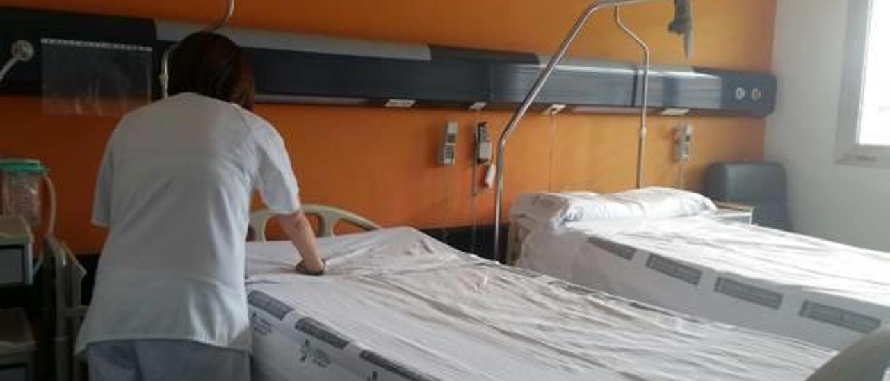 Una enfermera prepara la segunda cama introducida en una habitación individual del hospital.