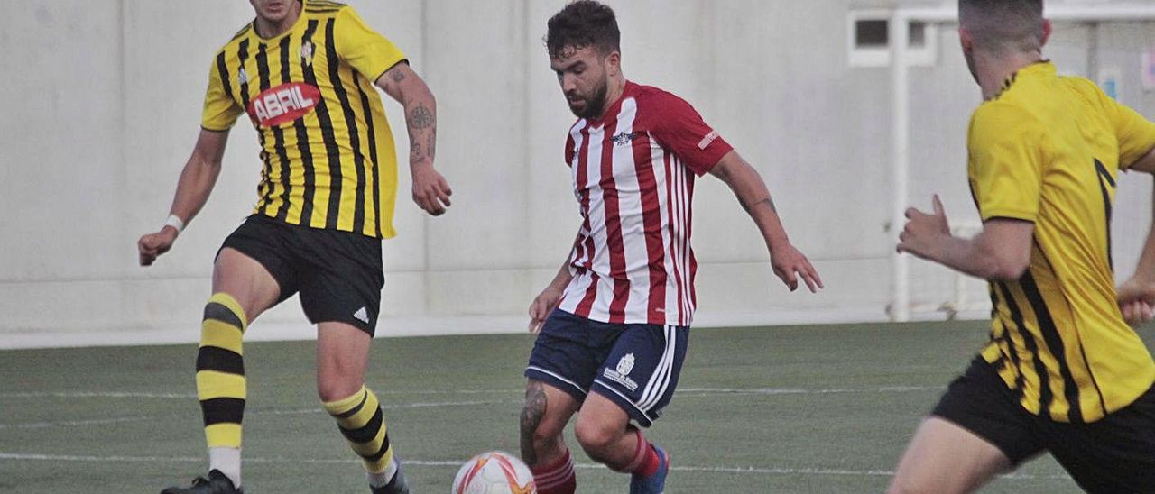 Óscar Martínez entre dos futbolistas del Rápido de Bouzas en el partido del sábado. | // SANTOS ÁLVAREZ