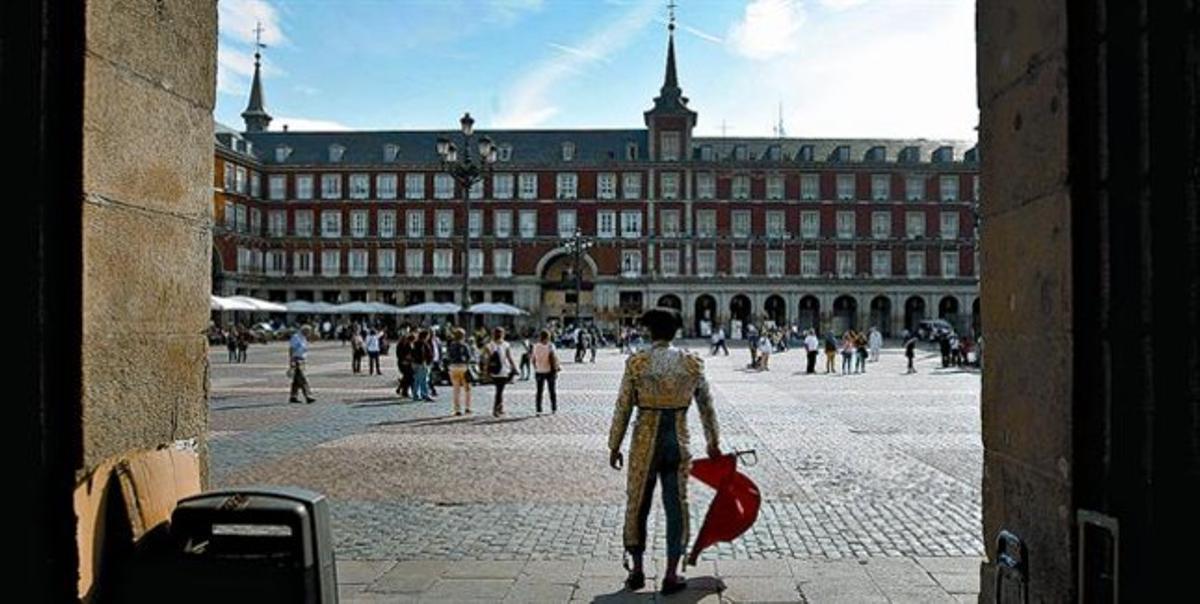 Un hombre vestido de torero intenta atraer la atención de los turistas en la plaza Mayor de Madrid, el viernes.