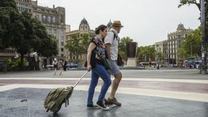 Una pareja de turistas con sus maletas en Barcelona.