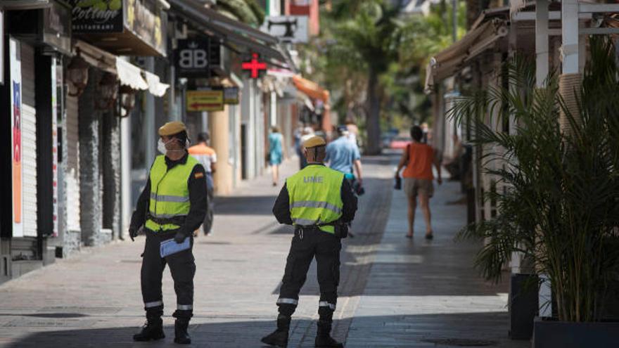 Un miembro de la UME observa los movimientos de unas personas en una calle de Los Cristianos.