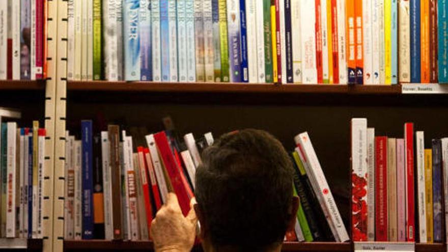 Un cliente consulta la sección de Autoyuda de una librería de Alicante.