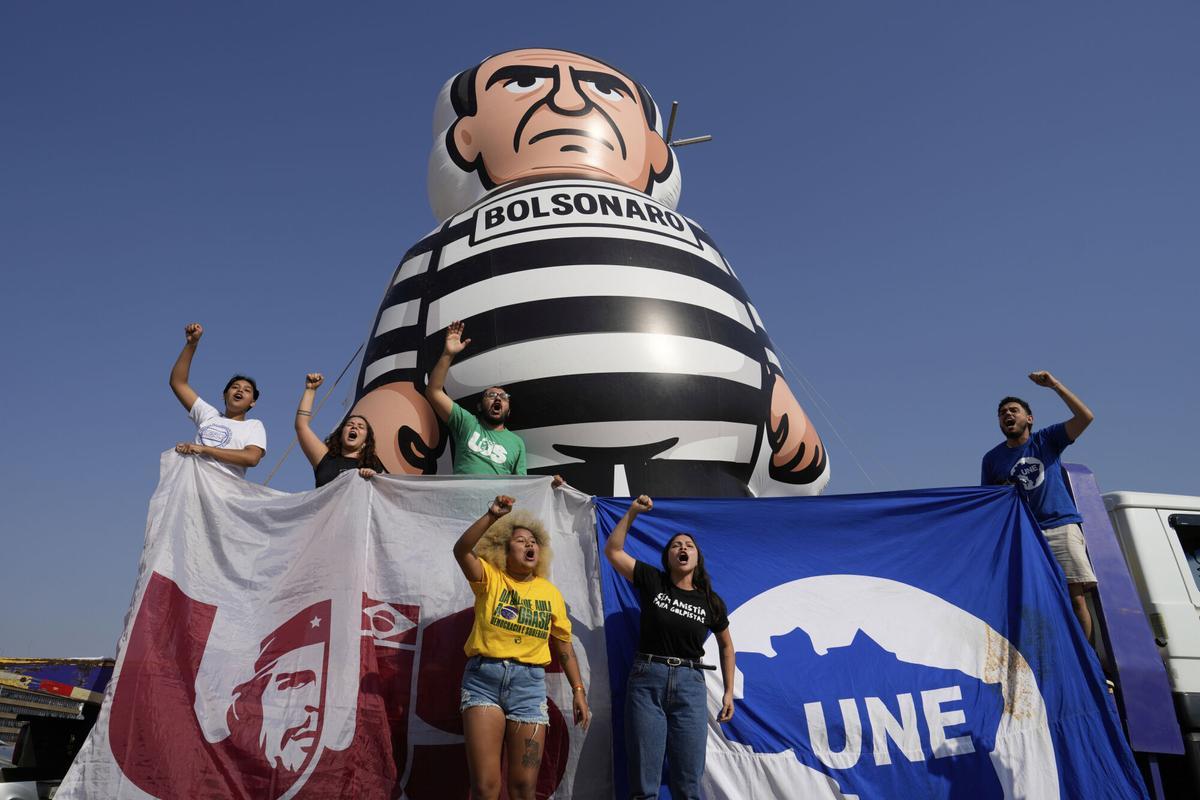 Estudiantes universitarios en Brasilia despliegan un muñeco gigante del expresidente de Brasil, Jair Bolsonaro, vestido con ropa de preso.