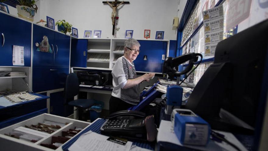 Marisol Alonso, titular de la administración de lotería Santa Ana de Candelaria, atiende a unos clientes.