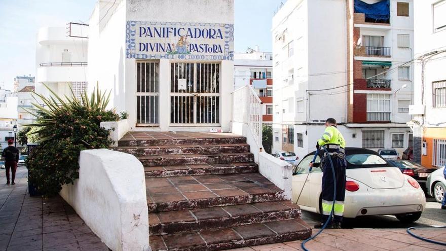 Un operario limpia una calle en el barrio de Divina Pastora