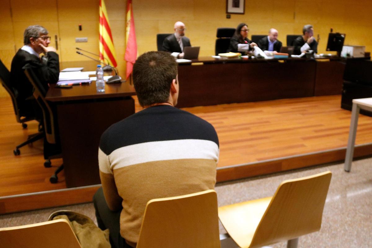 D'esquenes, l'acusat d'agredir sexualment i de manera continuada una noia a Empuriabrava. Foto del judici a l'Audiència de Girona