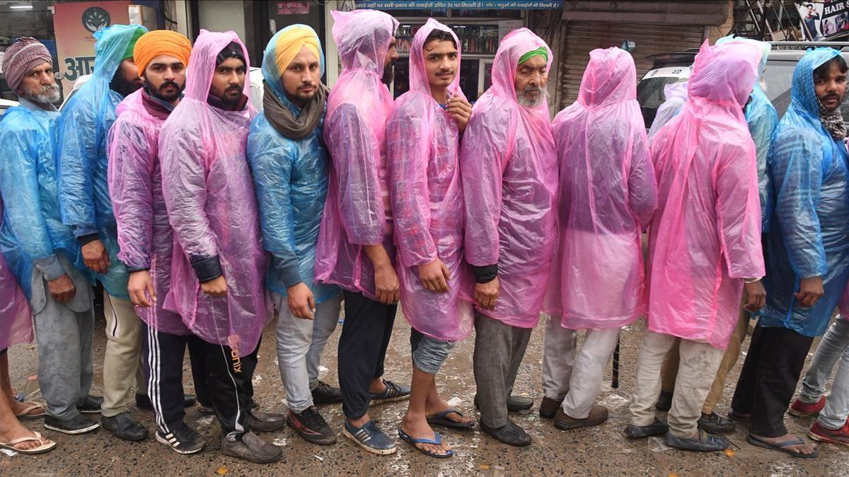 New Delhi (India)  05 01 2021 - People from farming communities and others queue up  wearing raincoats to get food from a community kitchen at the site of the farmers ongoing sit-in protest on a cold and rainy day at the New Delhi - Haryana  Singhu border  India  05 January 2021  Thousands of farmers gathered and tried to cross the sealed New Delhi border points to hold protests against the government s new agricultural laws and to demand for repealing the laws  Farmers have been stopped by the police at the various points outside Delhi border which are connected with neighboring states of Haryana and Uttar Pradesh and since then farmers have been holding a sit-in protest there  The latest round of the farmers talks with the government on 04 January has not yielded any result and farmers continued their protest for the 41st consecutive day  (Protestas  Estados Unidos  Nueva Delhi) EFE EPA STR