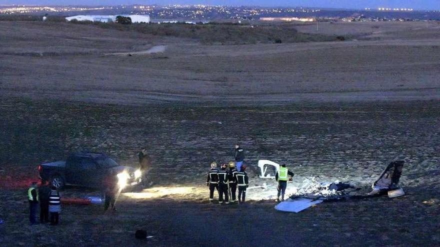 Efectivos policiales y bomberos, junto a los restos de la avioneta.